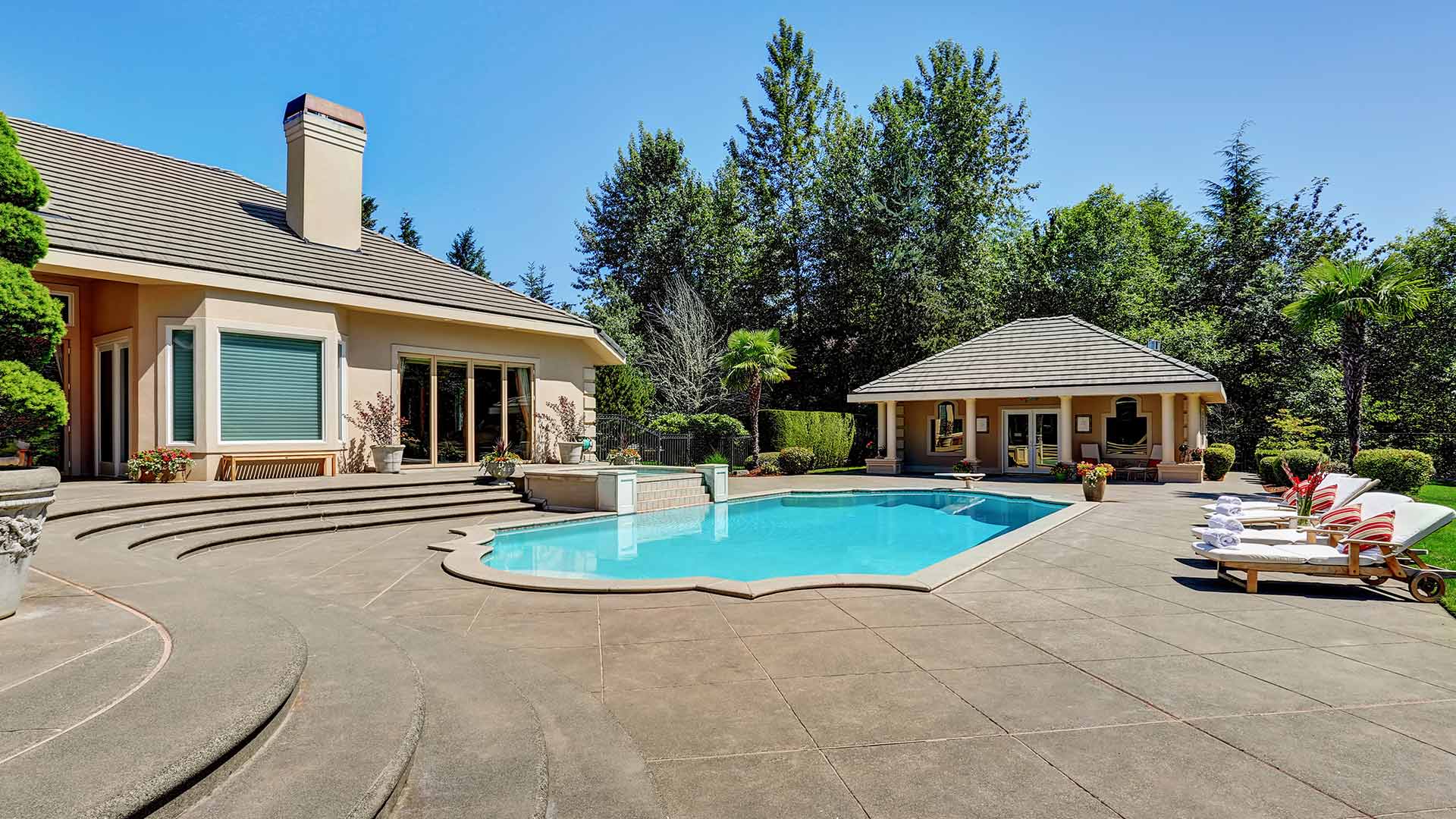 inground pool in backyard with stone walkways